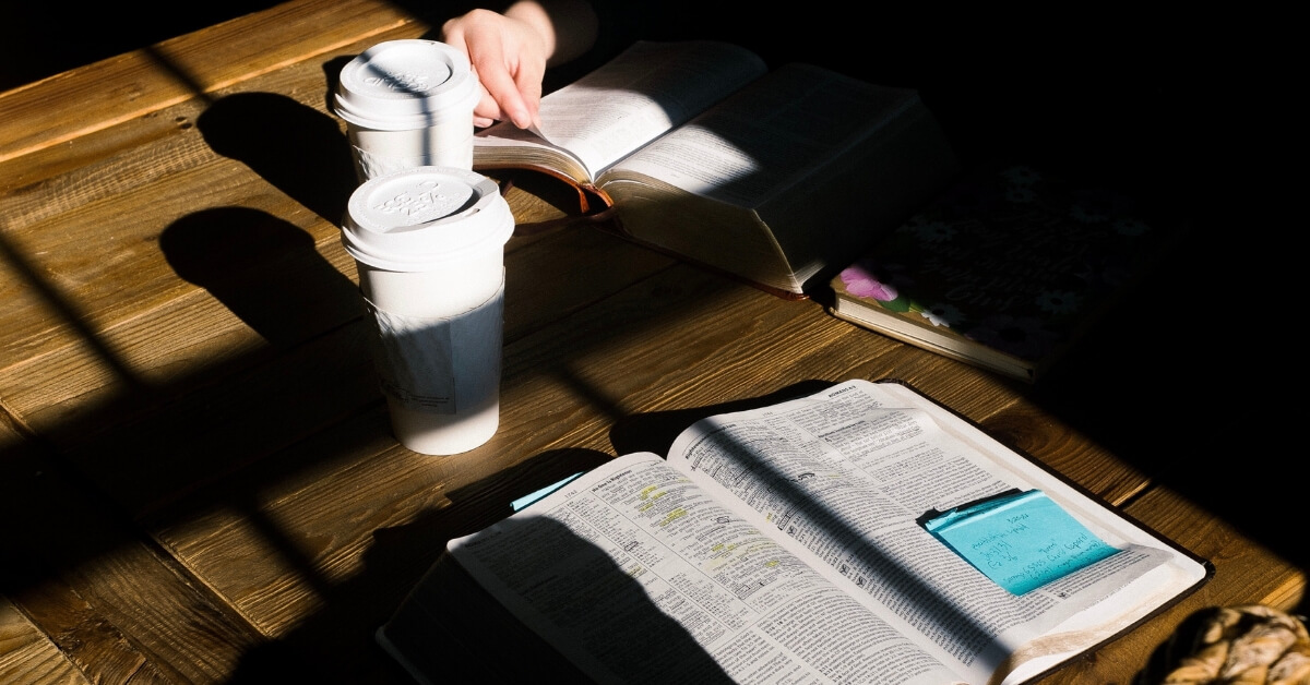 two bibles and coffee cups on a table
