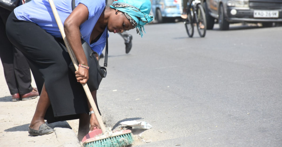 Woman sweeping gutter