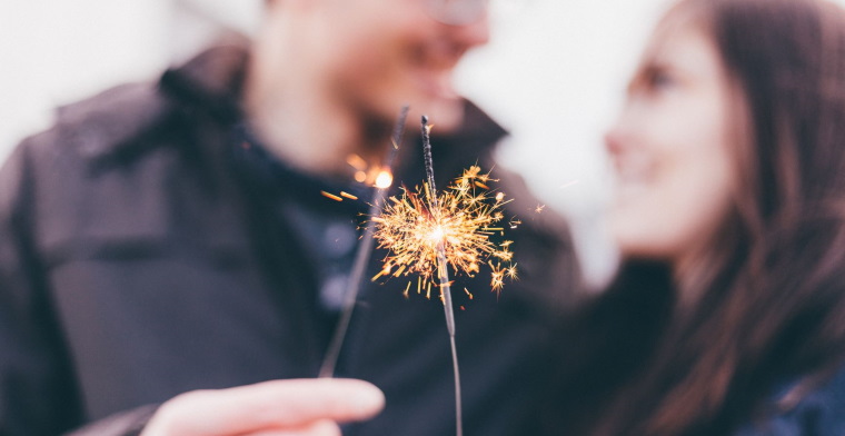 Blurred image of couple with sparklers in forground