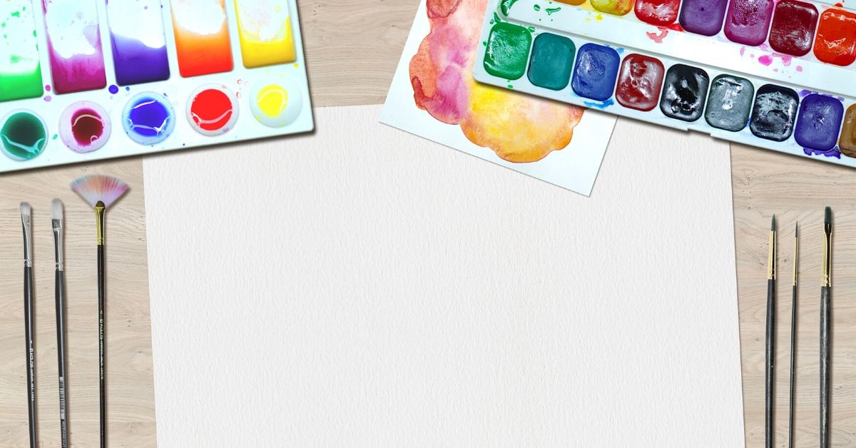 photo of watercolour paints, brushes and paper