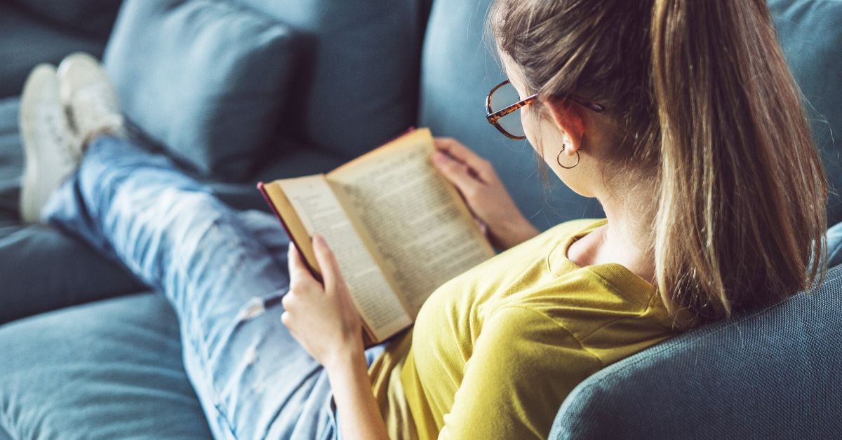 photo of a girl reading on the couch at home
