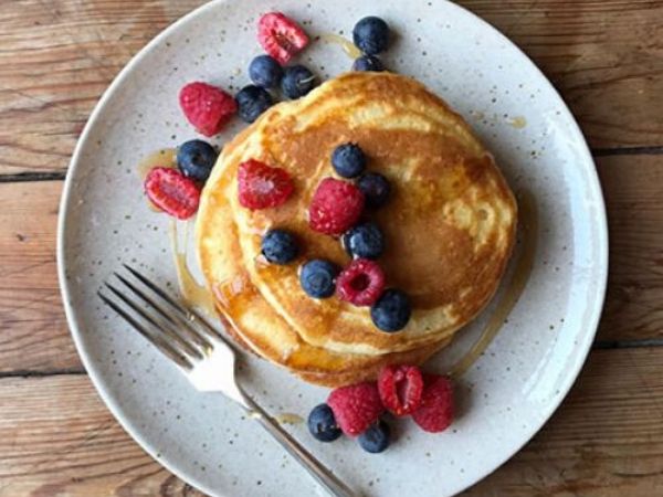 photo shows pancake stack topped with berries and syrup