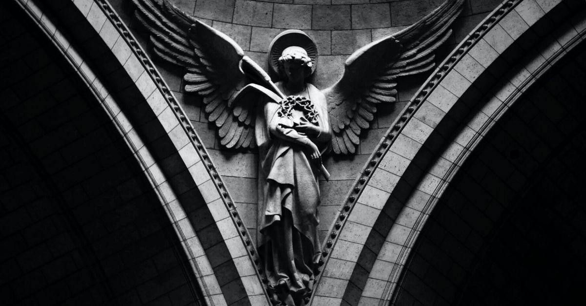 photo shows a shadowy stone angel statue