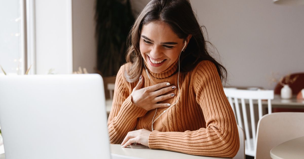 photo of woman smiling at computer