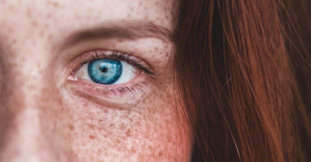 a freckled face and close up of piercing blue eyes