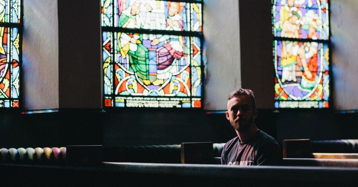 man sitting in a church pew alone