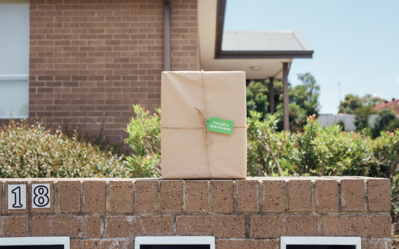 wrapped gift siting on a brick wall