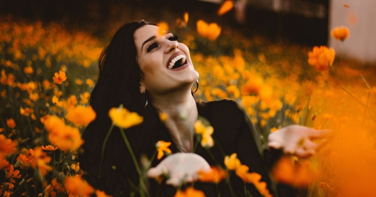 happy girl sitting in a field of flowers