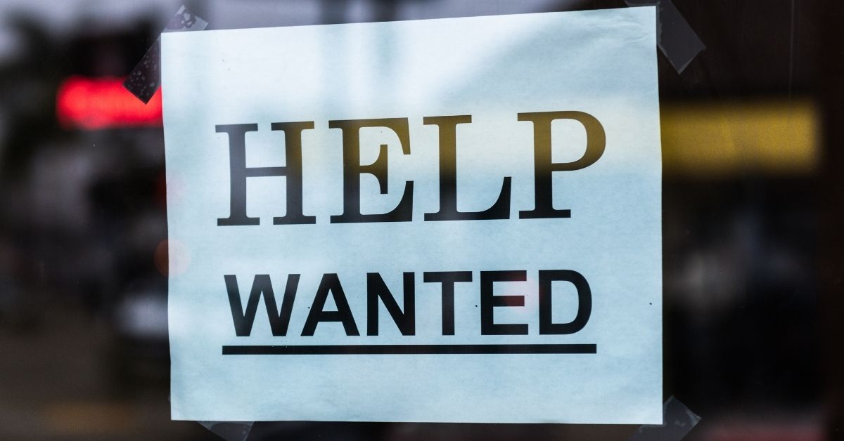 a help wanted sign in a shop window