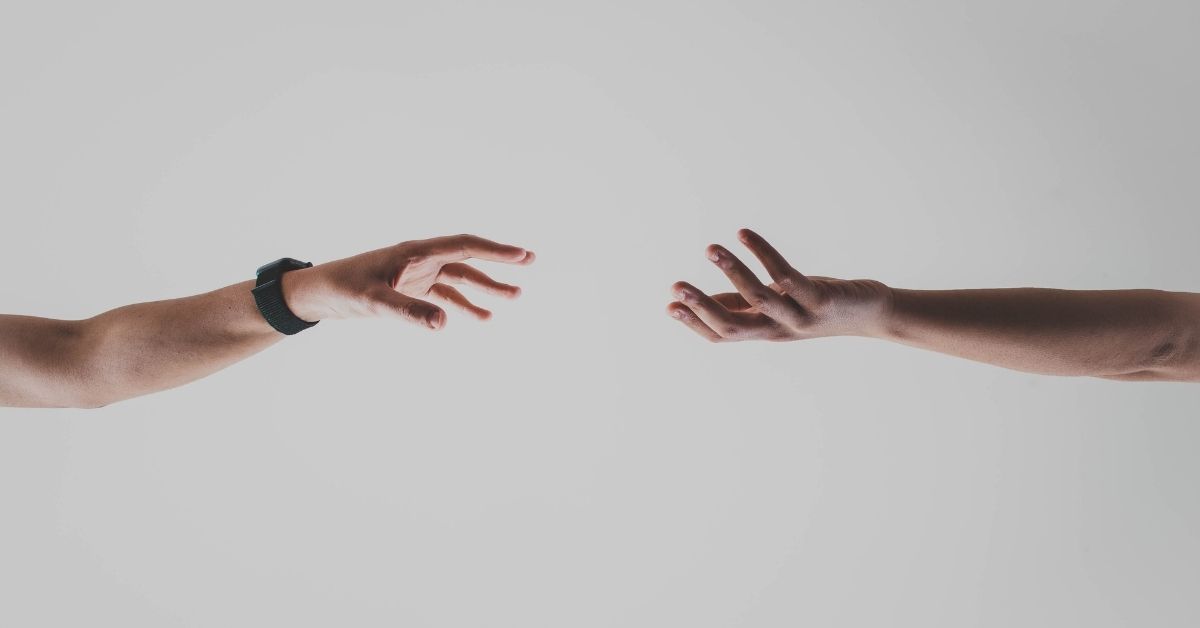 two hands outstretched towards each other but not touching