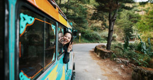 Smiling girl poking her head out of a brightly painted bus