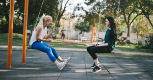 Women talking on park swings