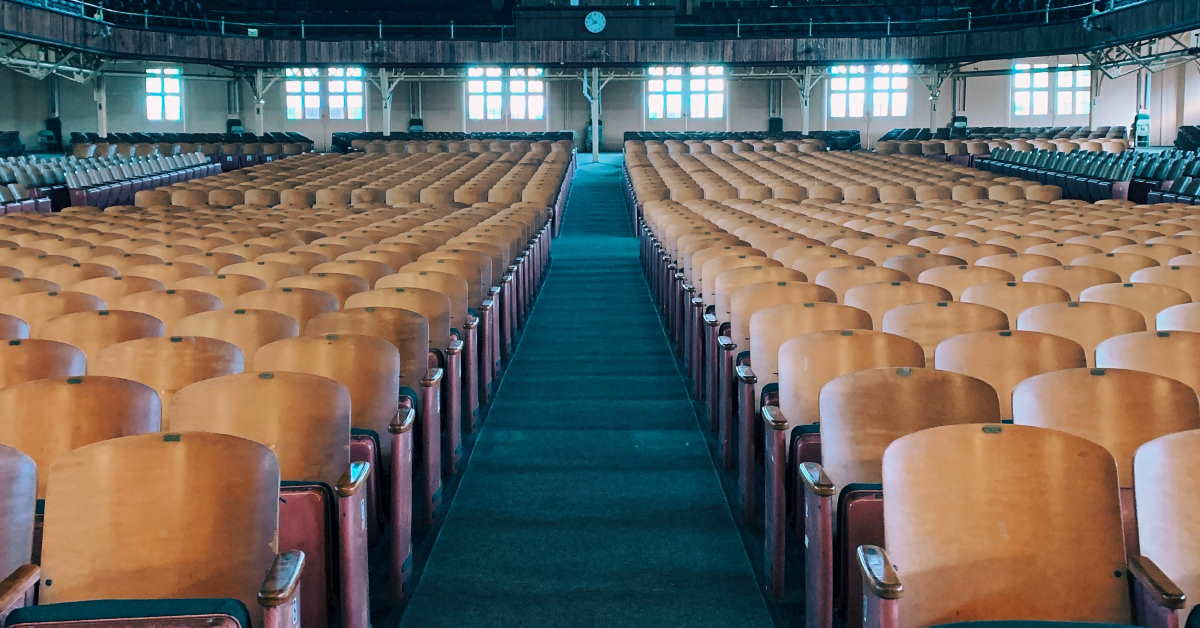 Rows of empty chairs in a large auditorium church like building