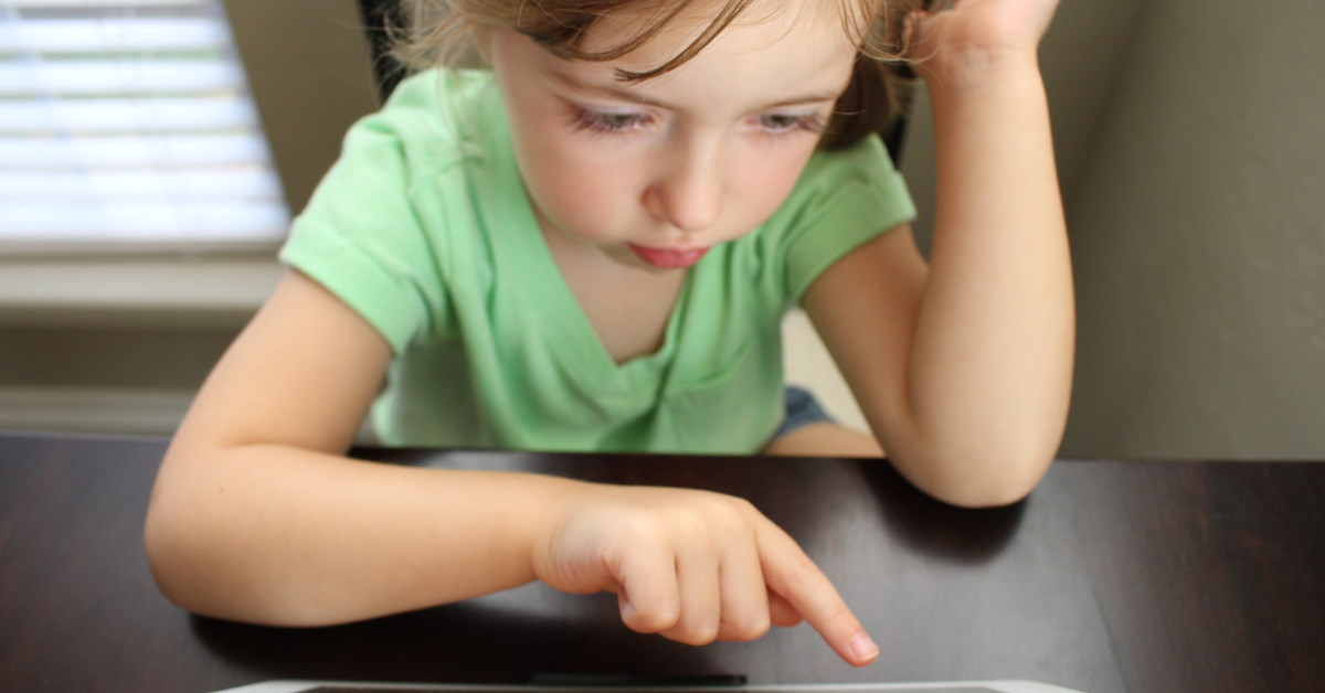 child searching ipad screen for information