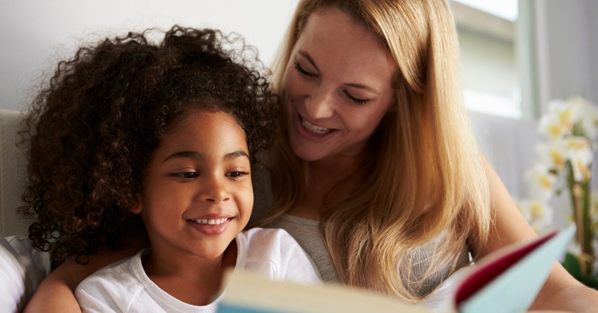photo of a mother and daughter reading a book together