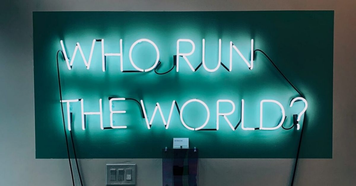 teal neon lights on a tv screen which says who run the world