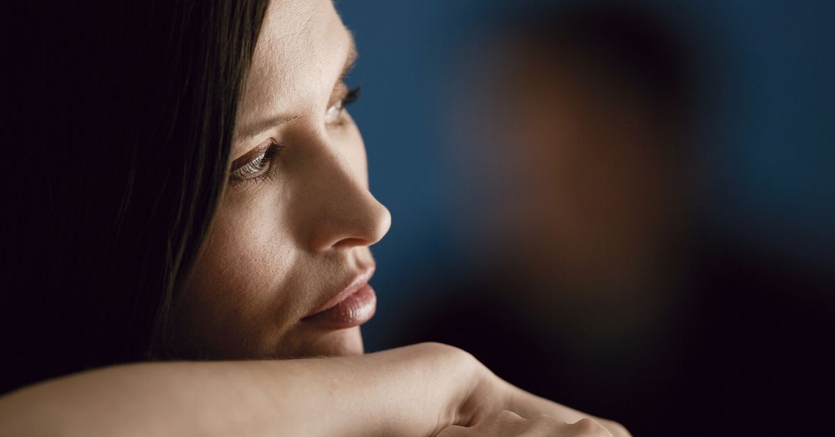 woman resting chin on her arm looking contemplative