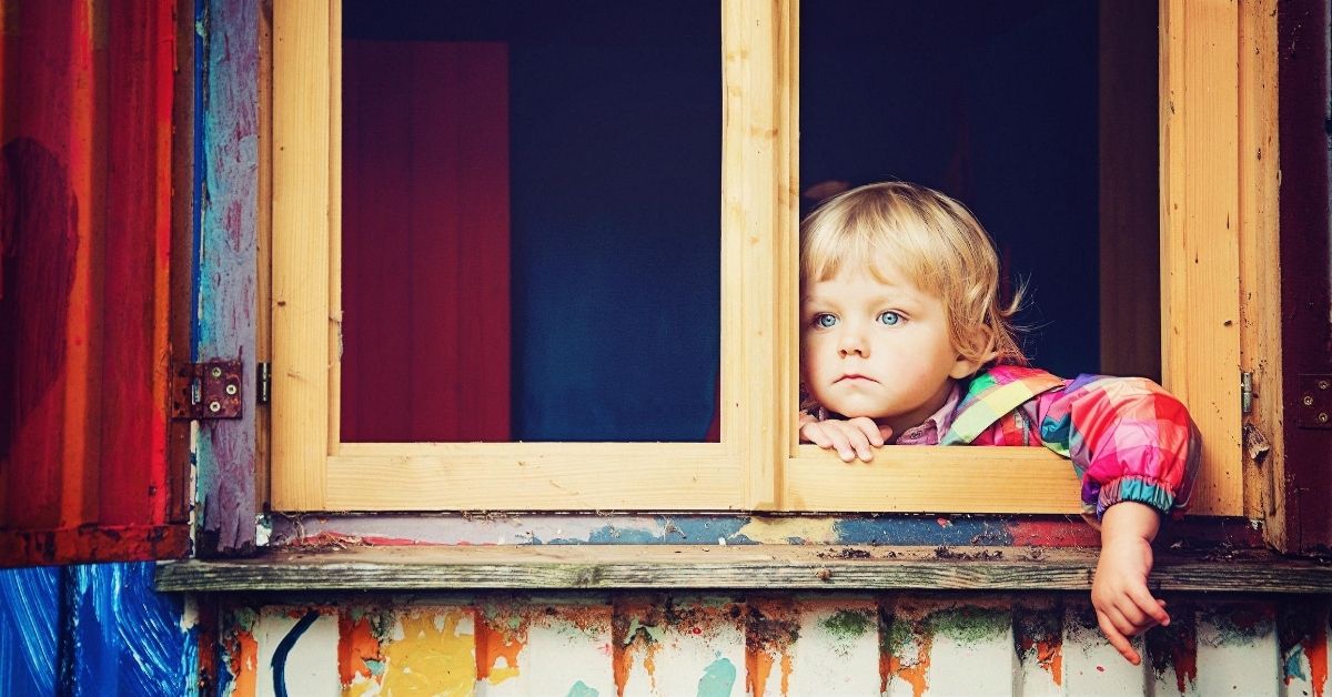 child gazing blankly out of a window