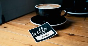 name tag next to mug of coffee which reads hello my name is karen