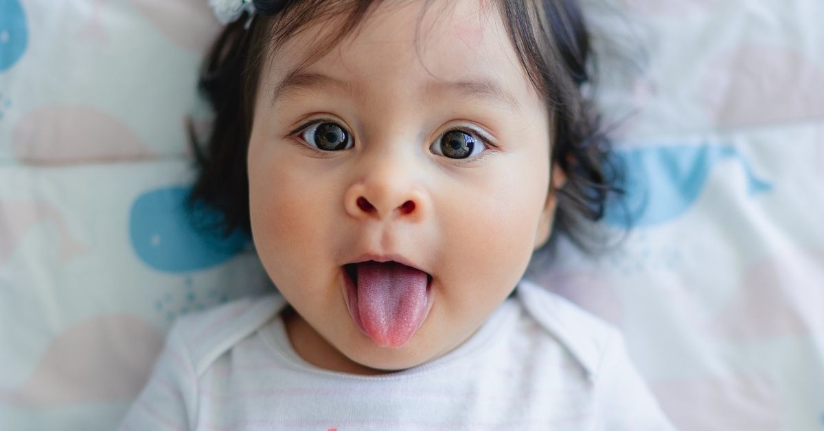 a cute baby girl sticking her tongue out