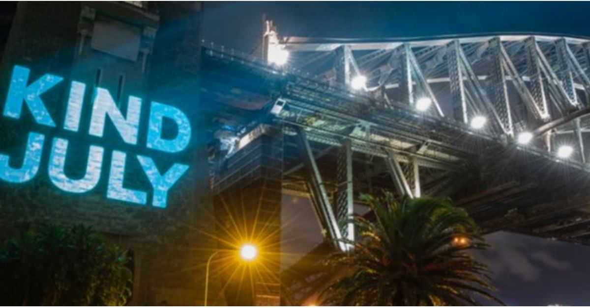 big neon sign saying kind july on the side of the sydney harbour bridge