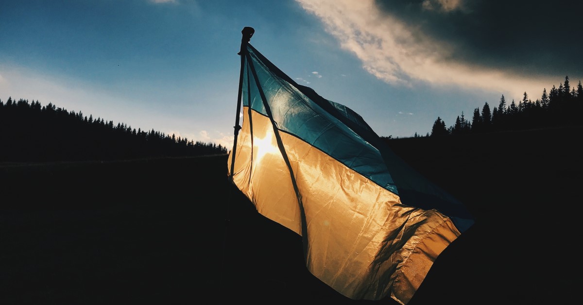 Ukraine Flag waving with hills and sunlight behind it