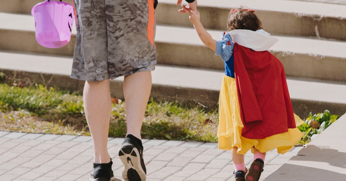 bottom half of parent and child in snow white costume walking