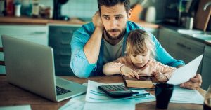 Dad doing finances with daughter on lap