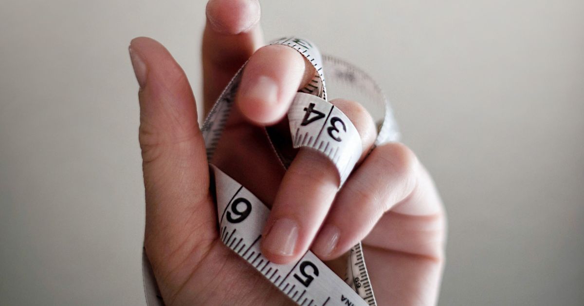 Person's hand holding a tape measure