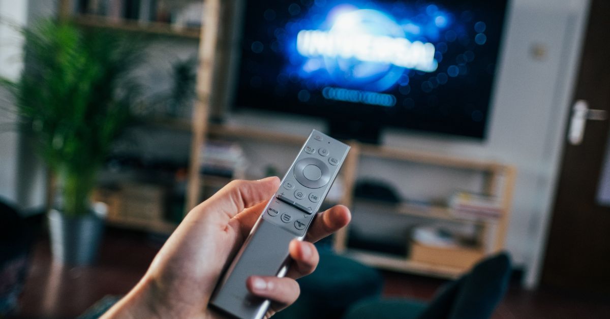 A hand holding TV remote