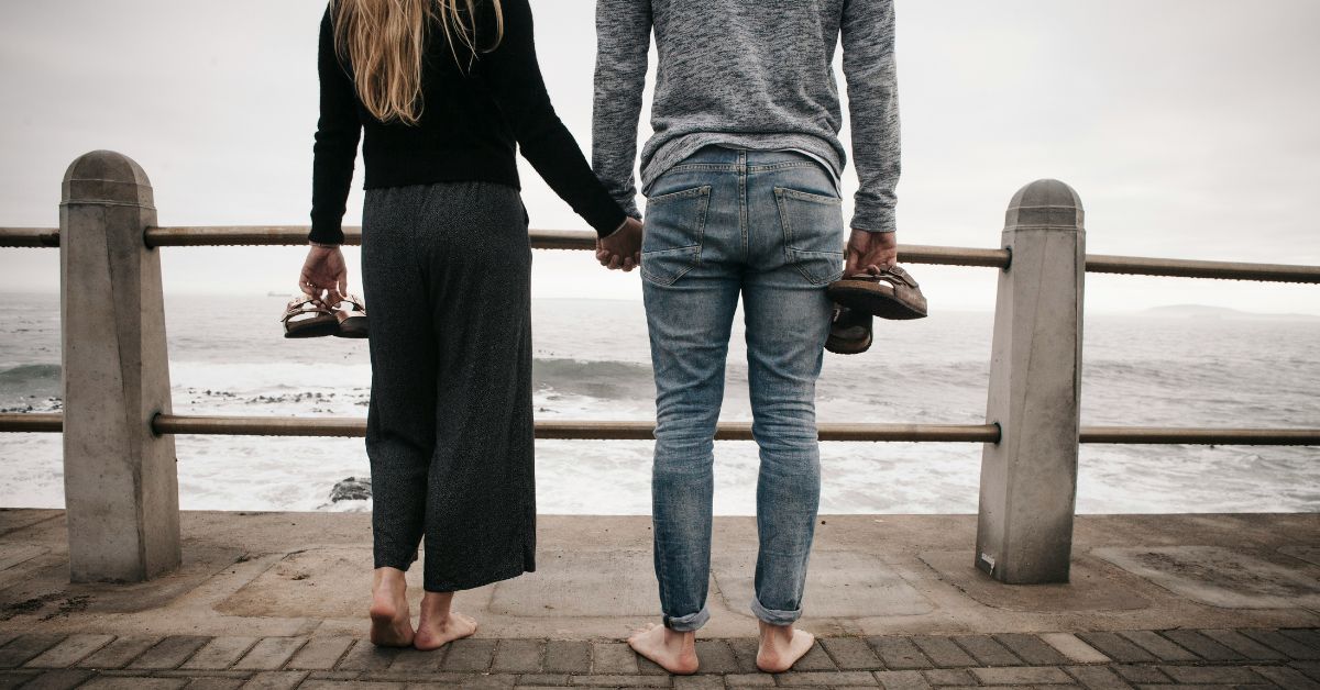 Couple walking barefoot by sea
