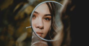 Young woman looking in mirror